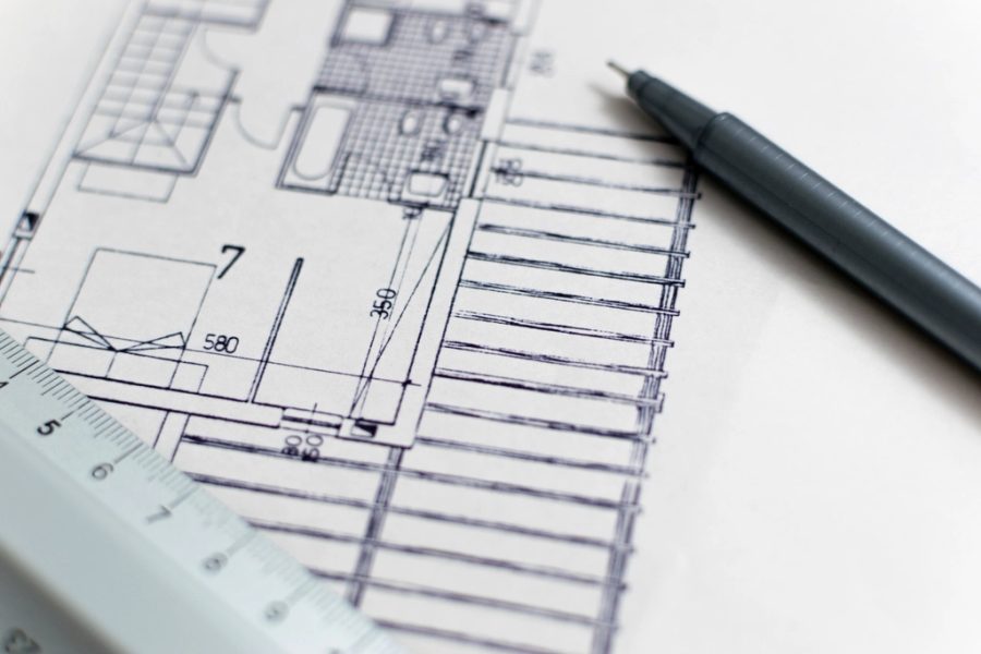 Planta e desenho técnico sendo elaborados sobre a prancheta